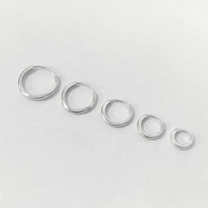 Set of five various sizes minimalist 925 sterling silver hoop earrings on white background