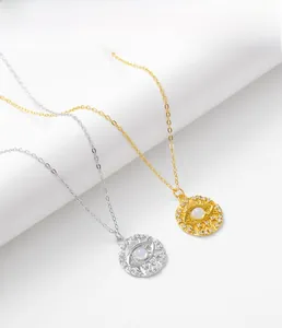 Vue détaillée des pendentifs œil maléfique en argent et or avec pierre de lune et cristaux