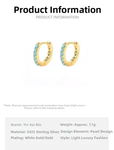 Detail of 925 sterling silver hoop earrings with gold plating and blue cubic zirconia stones