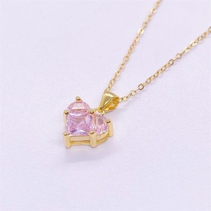 Détail d'un collier plaqué or avec un pendentif en forme de cœur en zircone rose