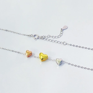 Minimalist S925 sterling silver necklace featuring three-color heart pendants in a clean view