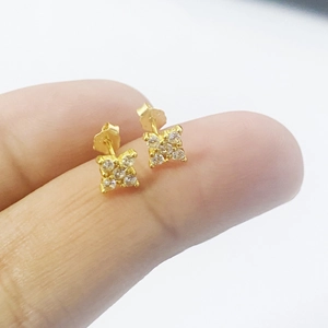 Minimalist S925 sterling silver gold flower stud earrings with CZ stones on a finger