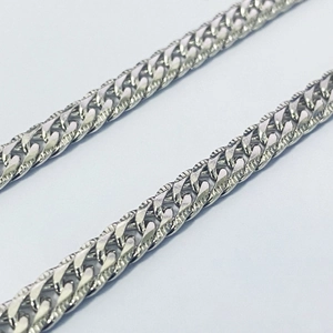 Macro shot of silver S925 sterling silver Cuban link chain with high-gloss mirror finish