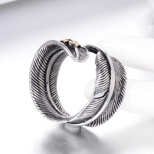 Retro feather open ring in vintage silver finish with a gold eagle emblem on a white base