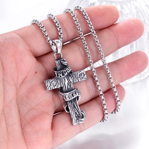 Détail macro du pendentif croix argent vintage avec texture bois In God We Trust
