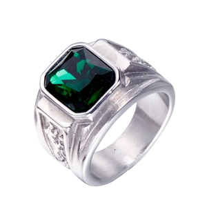 Vue macro d'une bague en titane avec pierre verte taille émeraude et anneau argenté ciselé