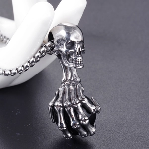 Détail macro du pendentif crâne gothique avec griffe squelette tenant une sphère noire