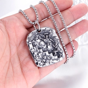 Gros plan détaillé d'un pendentif rectangulaire avec relief d'ange sur chaîne box