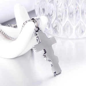 Détail macro du pendentif croix en acier inoxydable argenté avec finition brossée mat