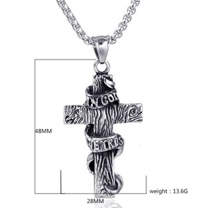 Détail d'un pendentif croix en acier inoxydable vintage avec ruban In God We Trust gravé