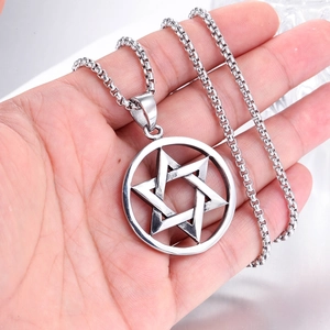 Gros plan d'un pendentif hexagramme argenté avec anneau métallique sur chaîne box