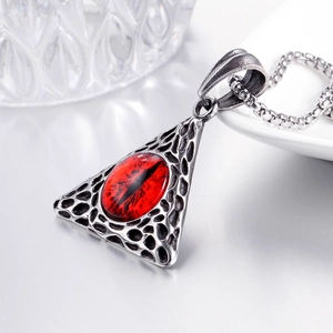 Gros plan du pendentif rétro en acier inoxydable avec œil de dragon rouge et texture alvéolée