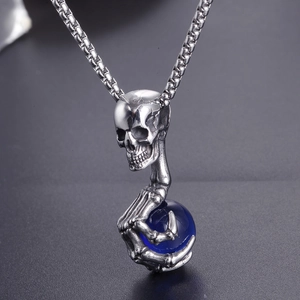 Vue macro d'un pendentif crâne gothique avec griffe et gemme bleue sur une chaîne