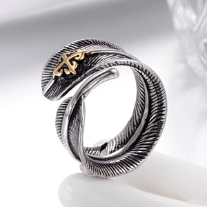 Vintage feather ring in adjustable stainless steel with golden cross emblem detail