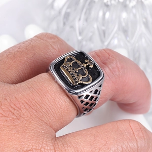 Macro d'une bague couronne carrée vintage pour homme avec relief doré sur noir