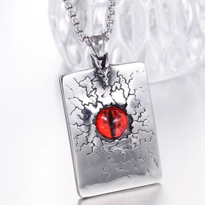 Vue macro d'un collier tête de dragon avec œil rouge sur pendentif en acier vintage