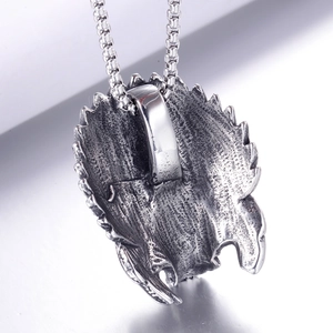 Vue macro du dos d'un pendentif aigle rétro en acier inoxydable avec chaîne à boîte ronde
