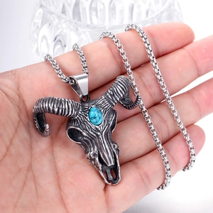 Macro shot of punk sheep skull pendant in vintage steel with blue turquoise stone inlay