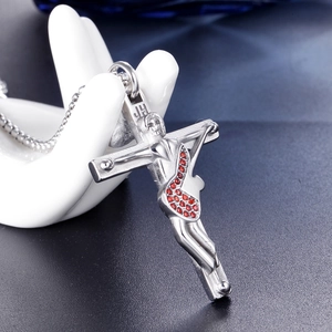 Macro detail of silver cross guitar pendant with red rhinestones on a bead chain