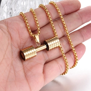 Vue macro du collier haltère doré avec gravure FIT GO sur une chaîne à mailles boîte