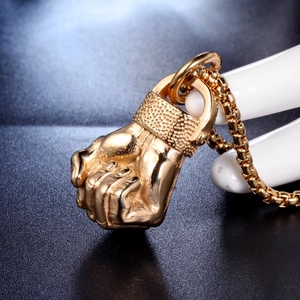 Polished gold stainless steel fist pendant necklace with classic box chain on black base