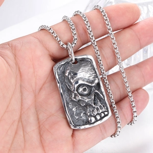 Detailed close-up of a men's punk gothic skull pendant on a stainless steel square chain