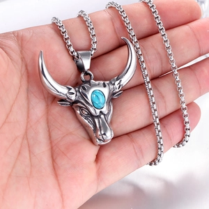Détail du pendentif tête de taureau vintage avec pierre turquoise dans la main