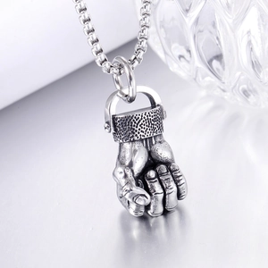 Macro shot of silver fist pendant with hammered texture on a polished metal chain