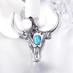 Détail du pendentif tête de taureau vintage avec pierre turquoise sur chaîne box