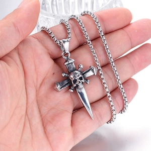 Macro detail of gothic skull cross dagger pendant in retro silver stainless steel