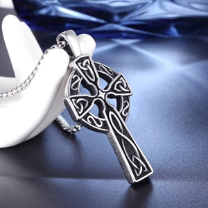 Detailed close-up of a vintage stainless steel Celtic cross pendant with intricate knots
