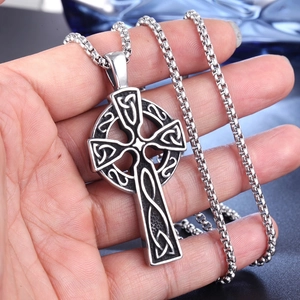 Detailed close-up of a Celtic cross pendant with vintage knot patterns and chunky chain