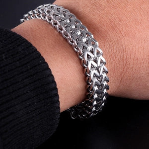 Close-up of men's stainless steel Franco weave bracelet worn on a dark sleeve
