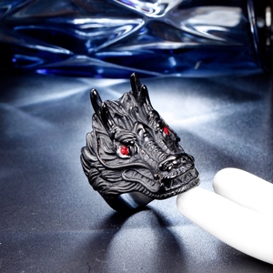 Detailed view of matte black titanium dragon ring with sparkling red gemstone eyes