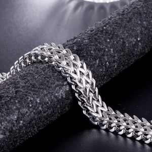 Macro detail of silver stainless steel double-row wheat chain with polished finish