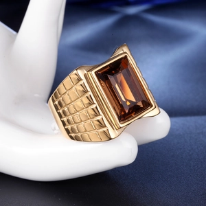 Detail shot of men's gold ring with rectangular brown gemstone and mesh texture