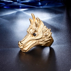 Macro shot of detailed golden dragon head ring featuring textured scales and black gemstone eyes
