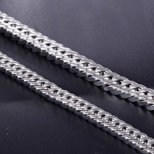 Close-up of polished stainless steel mesh chain links on a black leather surface