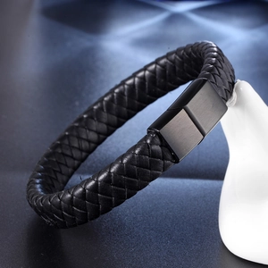 Men's woven black leather bracelet with a matte black magnetic clasp on dark background