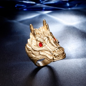 Detailed close-up of golden dragon head ring featuring vibrant red zircon gemstone eyes