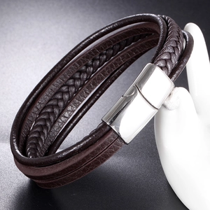 Macro detail of multi-layer braided leather bracelet with polished magnetic steel clasp