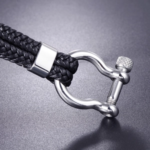 Macro detail of black braided leather bracelet with silver stainless steel anchor shackle