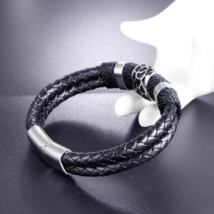 Close-up of men's braided leather bracelet with geometric metal bead and magnetic clasp