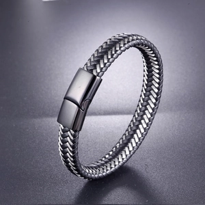 Minimalist woven leather bracelet for men with matte black magnetic clasp on grey background