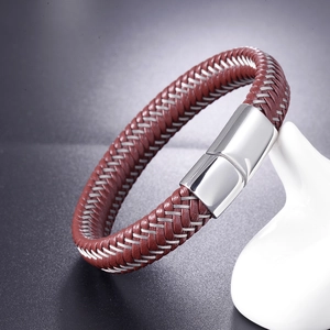 Gros plan d'un bracelet en cuir tressé marron avec fils d'argent et fermoir magnétique