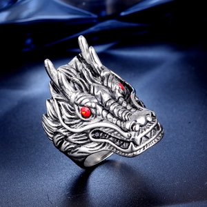 Detailed macro view of a silver dragon head ring featuring bright red zircon eyes