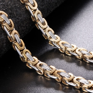 Polished gold and silver bicolor Byzantine chain necklace for men on a dark rock background