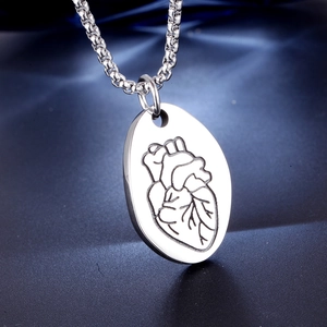 Collana con ciondolo cuore anatomico in argento lucido su sfondo di seta blu