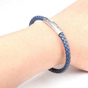 Close-up of deep blue braided leather bracelet with silver magnetic metal clasp on wrist