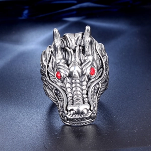 Close-up of dragon ring with detailed silver scales and two red gemstone eyes